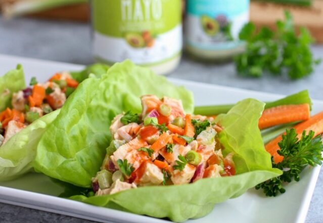 Buffalo chicken salad in lettuce cups with carrot and celery sticks and Primal Kitchen Mayo and Ranch Dressing.