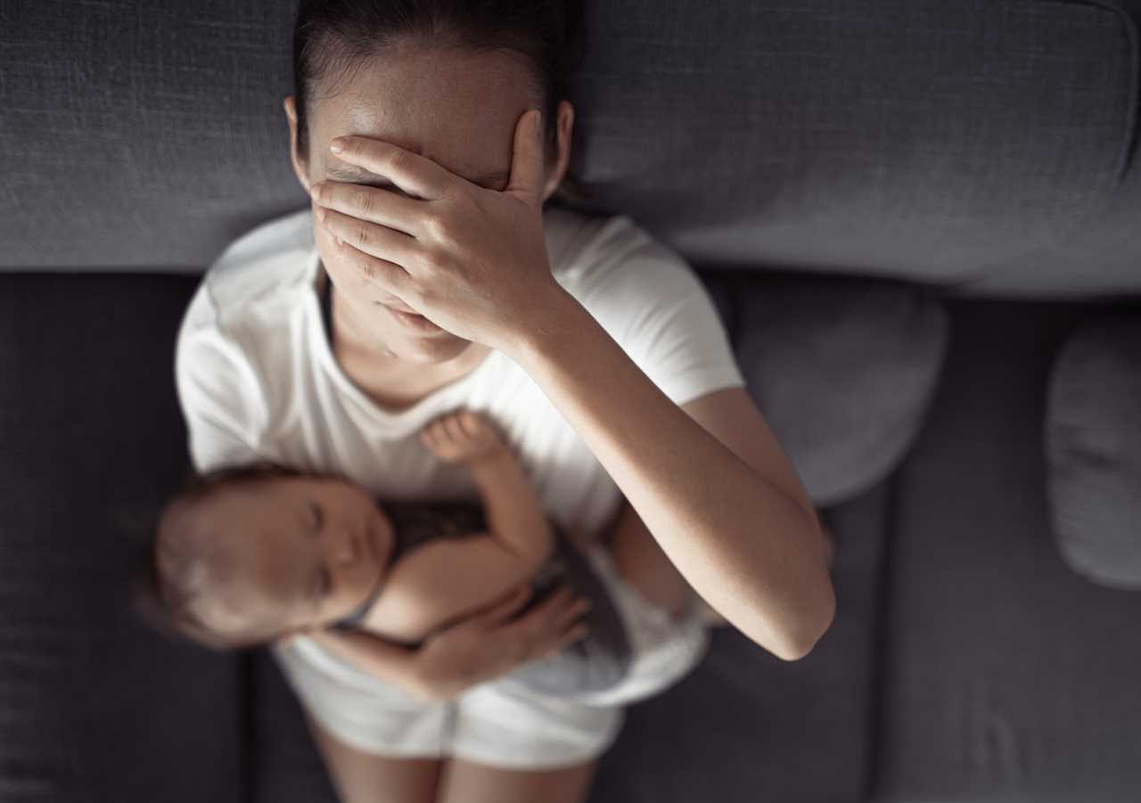 Tired mother having headache, stressed with baby child at home