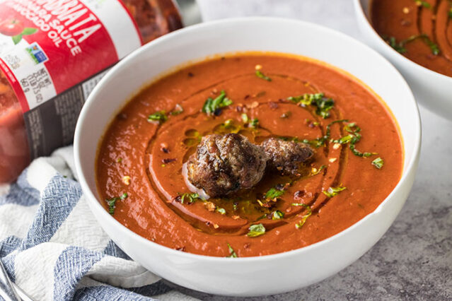 White bowl of tomato soup with spicy meatballs, Primal Kitchen Arrabbiata Sauce.