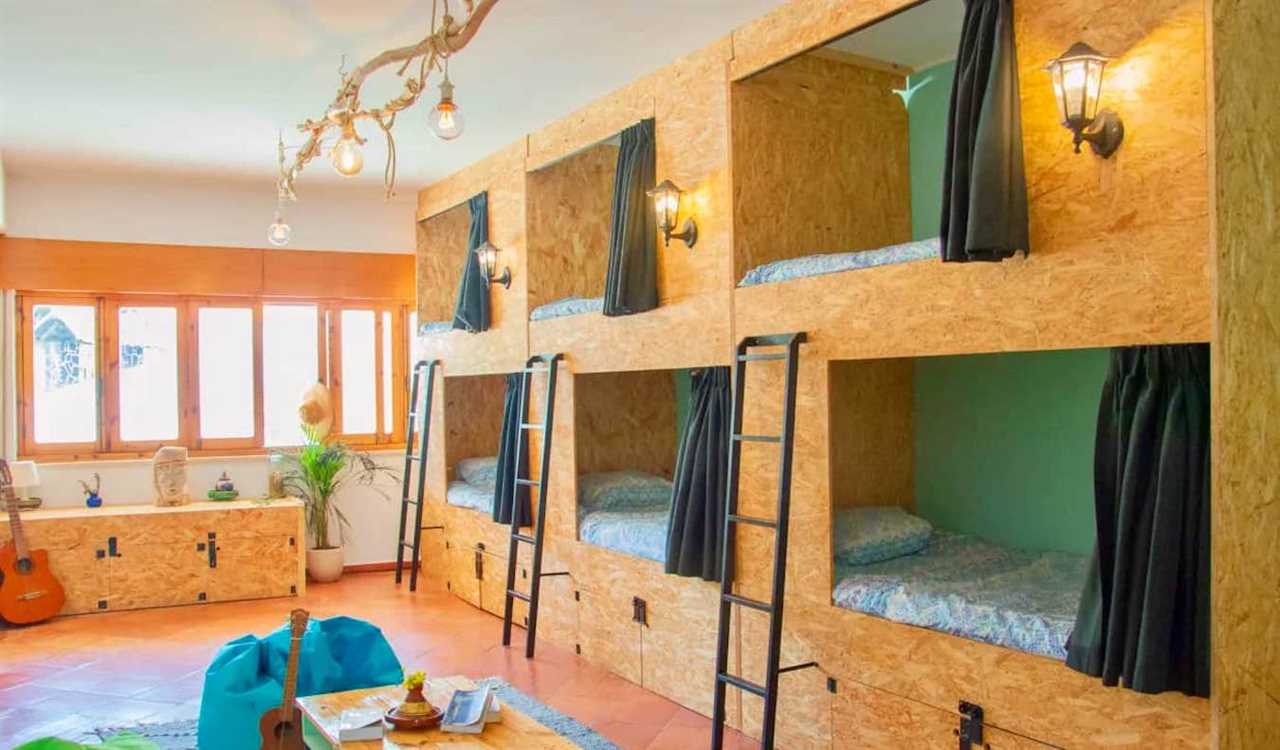 Wooden bunk beds in a large dorm room in the Banana Beach House hostel in Lagos, Portugal