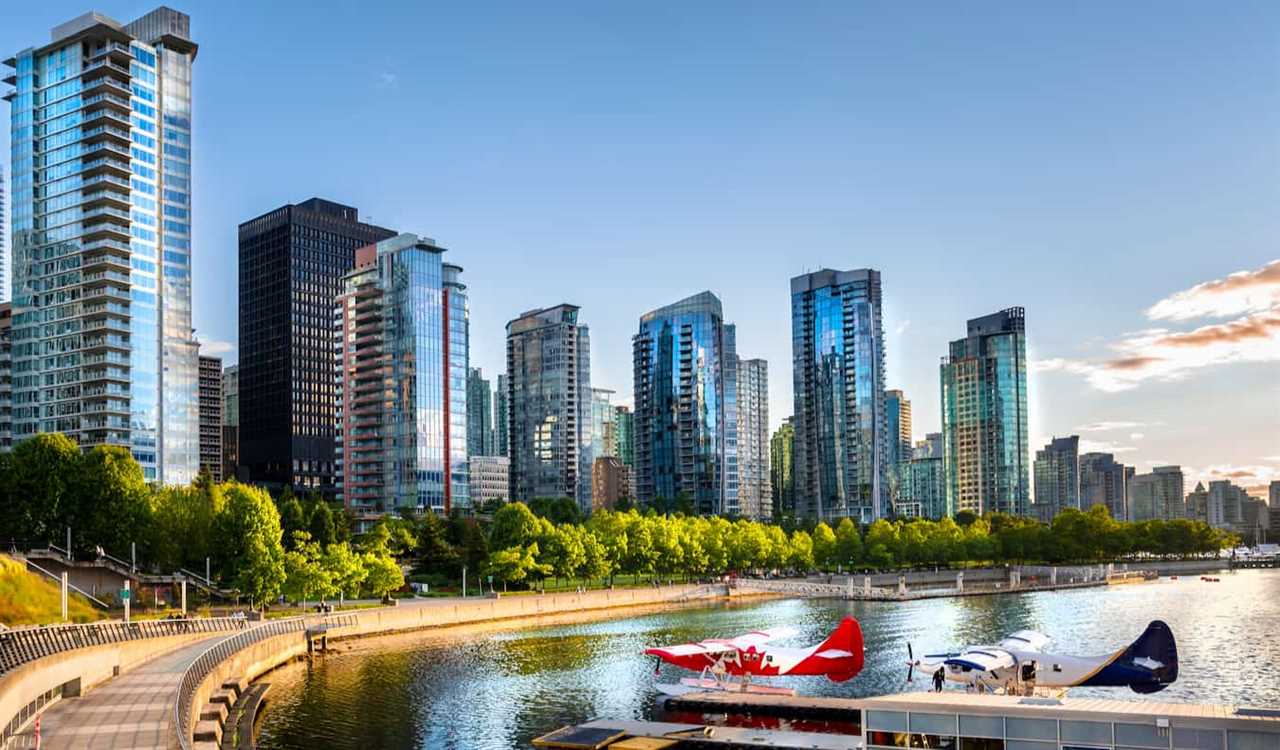 the stunning skyline of Vancouver, Canada as seen from above at sunset with mountains in the distance