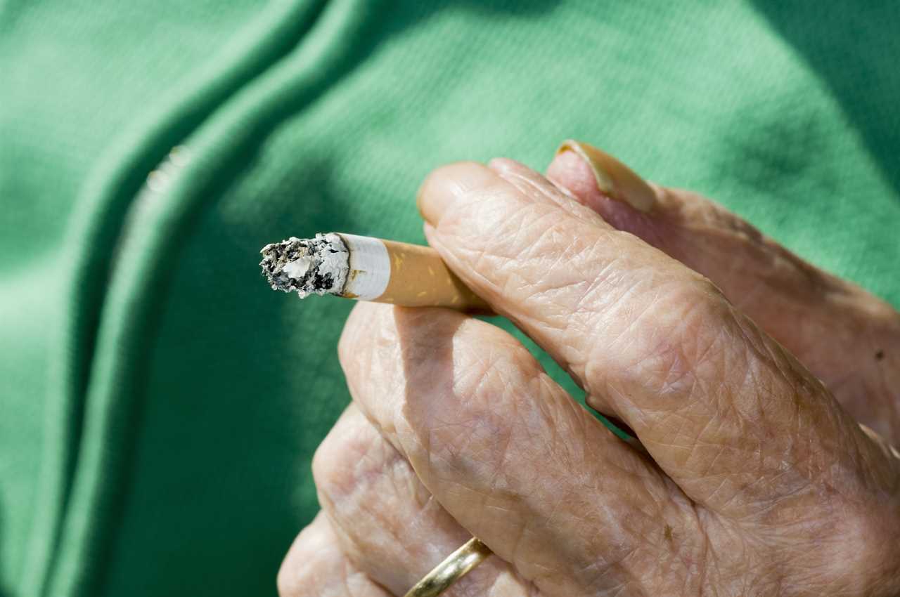 Elderly Hand Holding Cigarette Butt