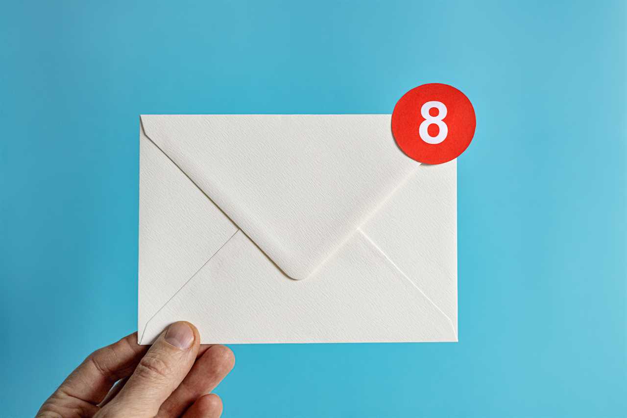 Hand holding white envelope with notification bubble