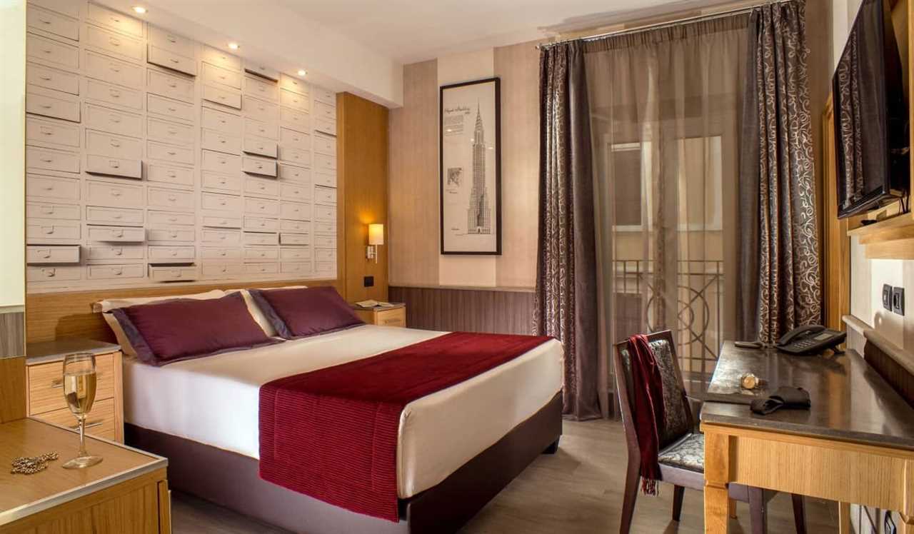 Guestroom with deep red accents and wooden furnishings at Hotel Royal Court in Rome, Italy