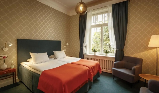 Simply decorated guestroom with a double bed and large windows at Parlan Hotel in Stockholm, Sweden