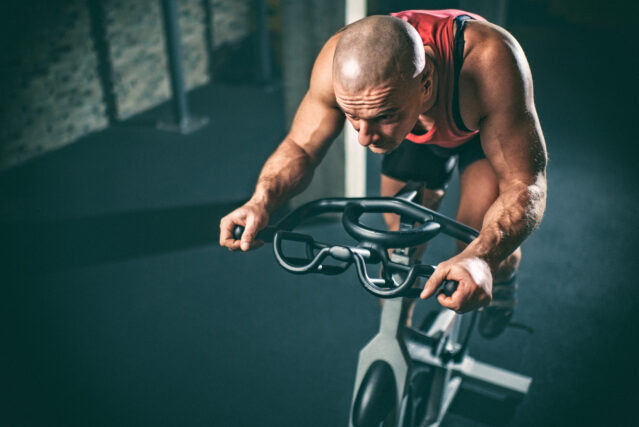 Man on stationary bicycle working hard.