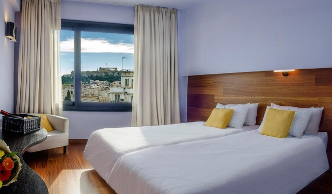 Guest room at Athens Center Square Hotel with a window open showing the Acropolis in the distance