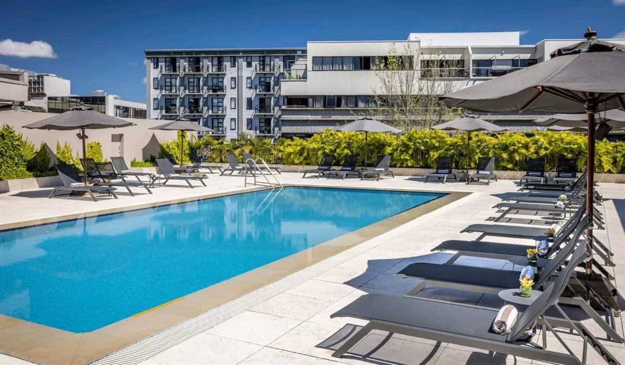 Outdoor pool surrounded by lounge chairs at Cordis hotel in Auckland, New Zealand