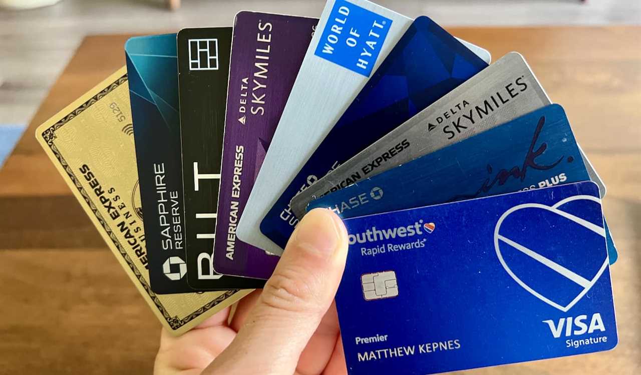 A bunch of different travel credit cards being held by avid traveler Nomadic Matt
