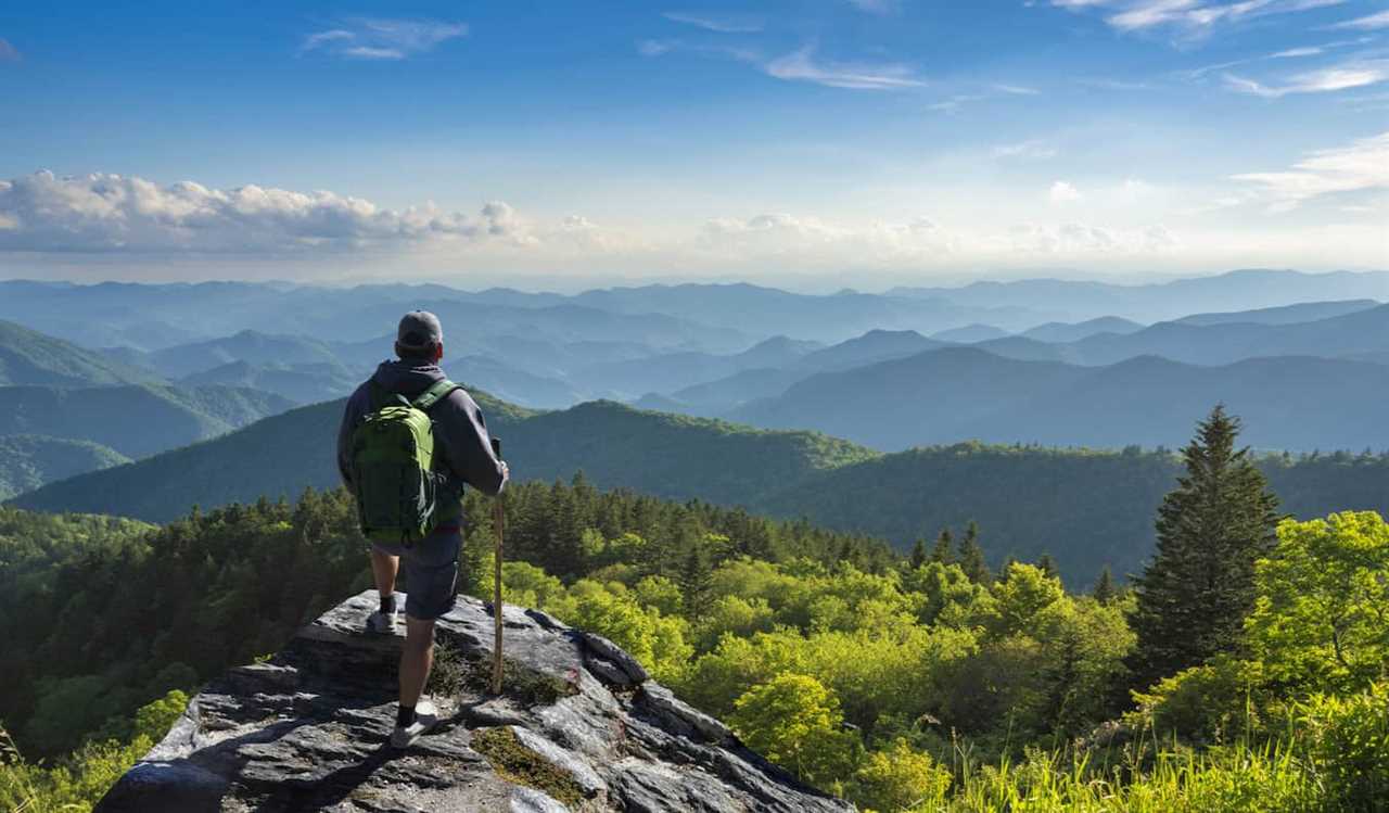 A lone hiker taking in the epic view while hiking in the mountains