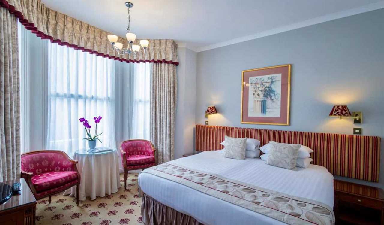 A large hotel room that looks like a B&B, with vintage decor, at the London Lodge Hotel in London, England