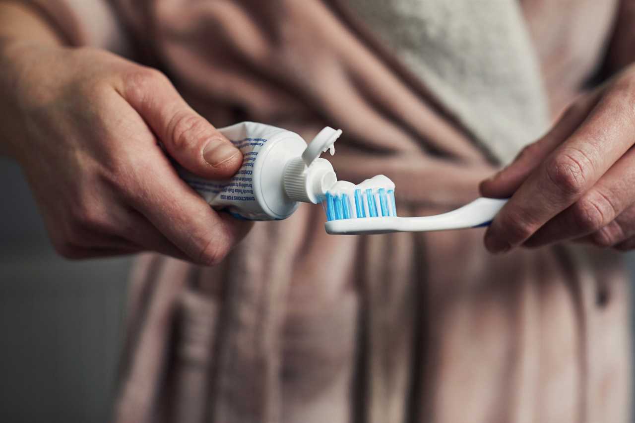 Woman putting toothpaste on a toothbrush