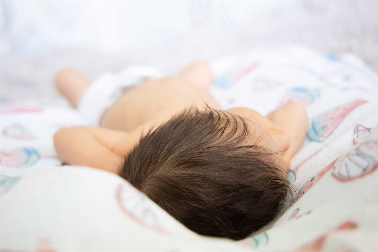 Newborn Baby laying down in the bed.