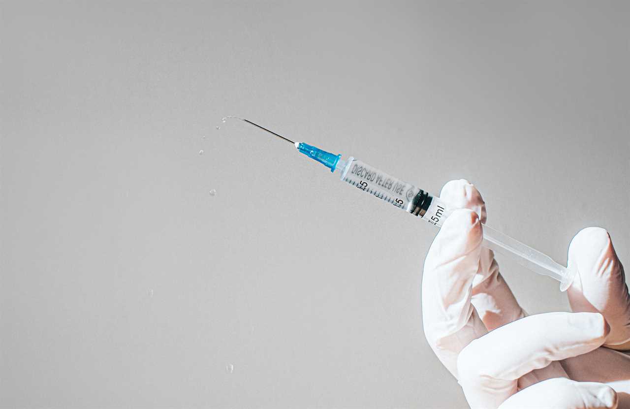 Gloved Hand holding a Syringe