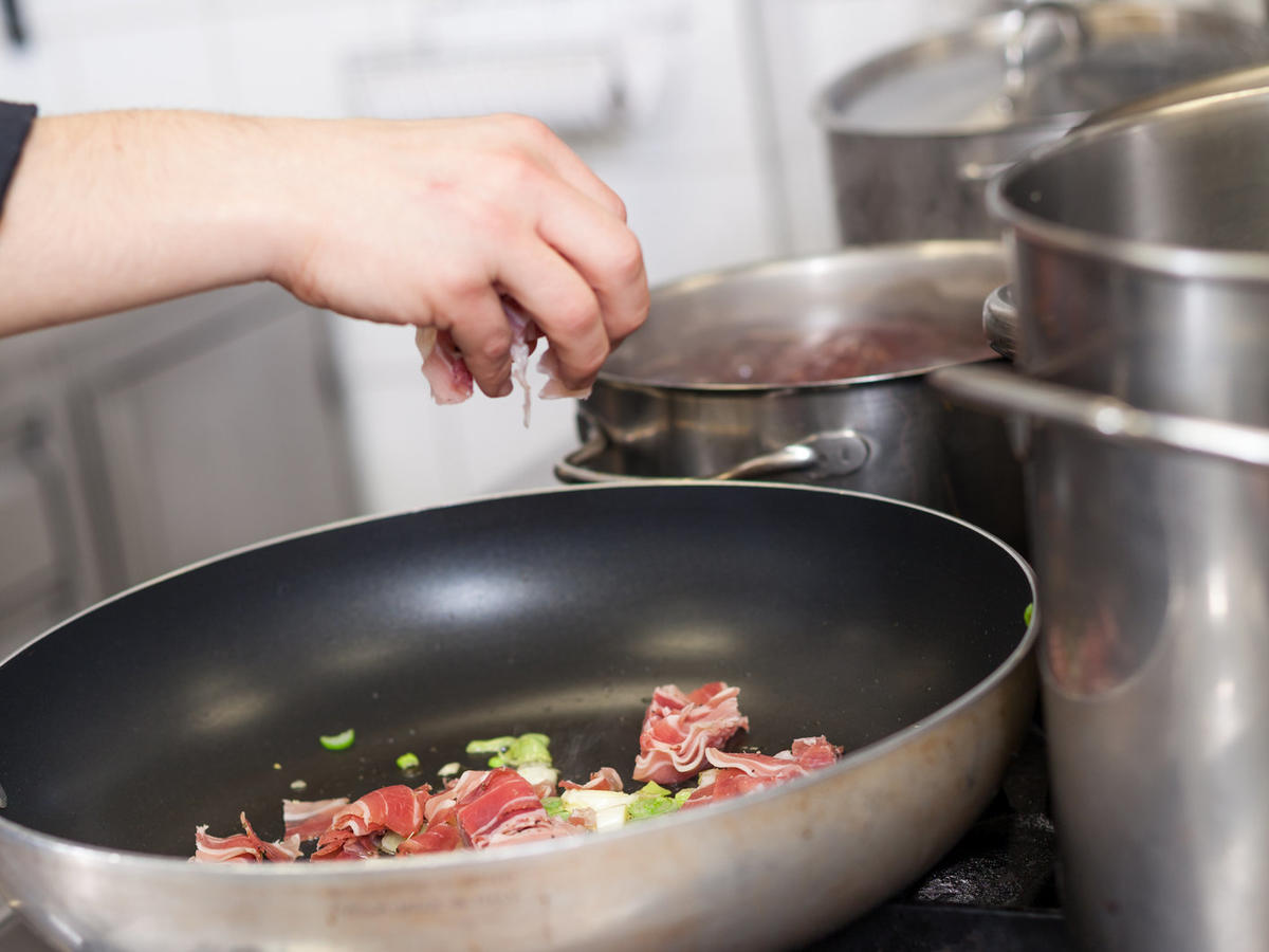 Chef or braising meat in a frying pan