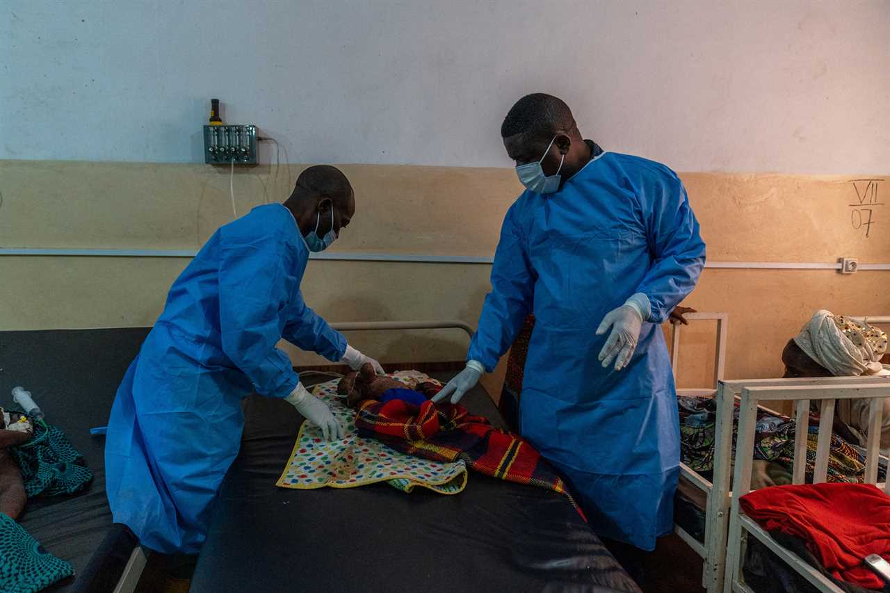 Dr. Robert Musole, medical director of the Kavumu hospital (right), consults an infant suffering from a severe form of mpox at the Kavumu hospital in Democratic Republic of Congo, Aug. 24, 2024.