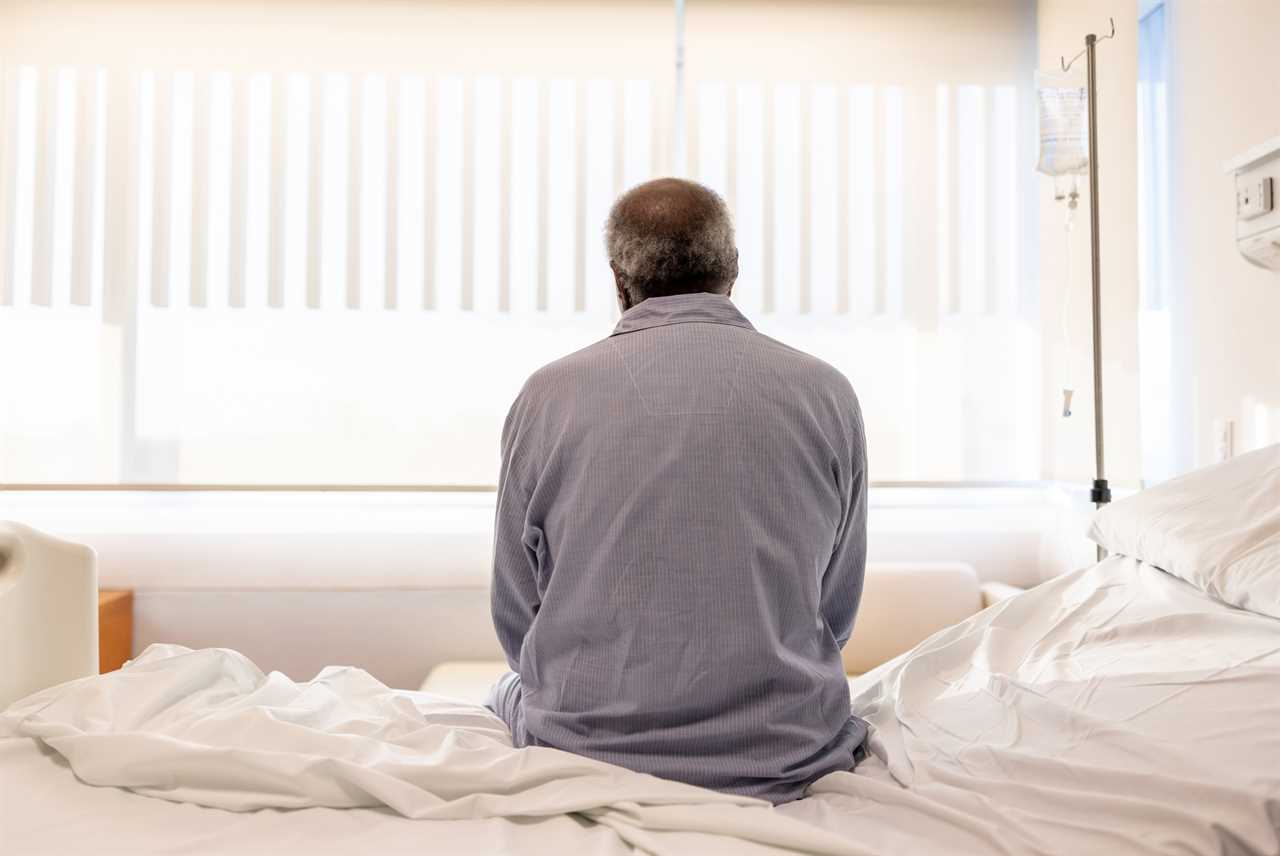 Sick man sitting on the bed at the hospital