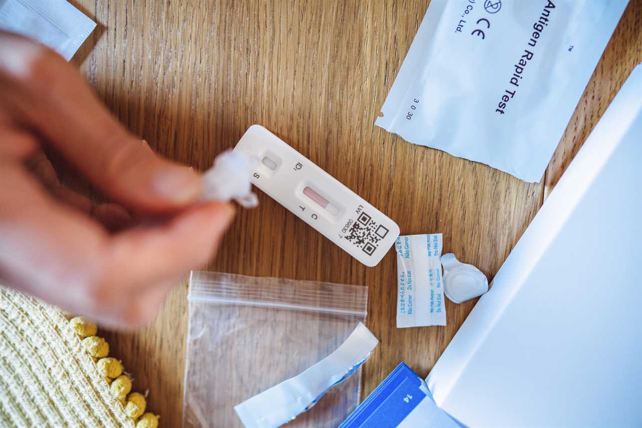 A woman using a Covid-19 rapid self-test kit at home