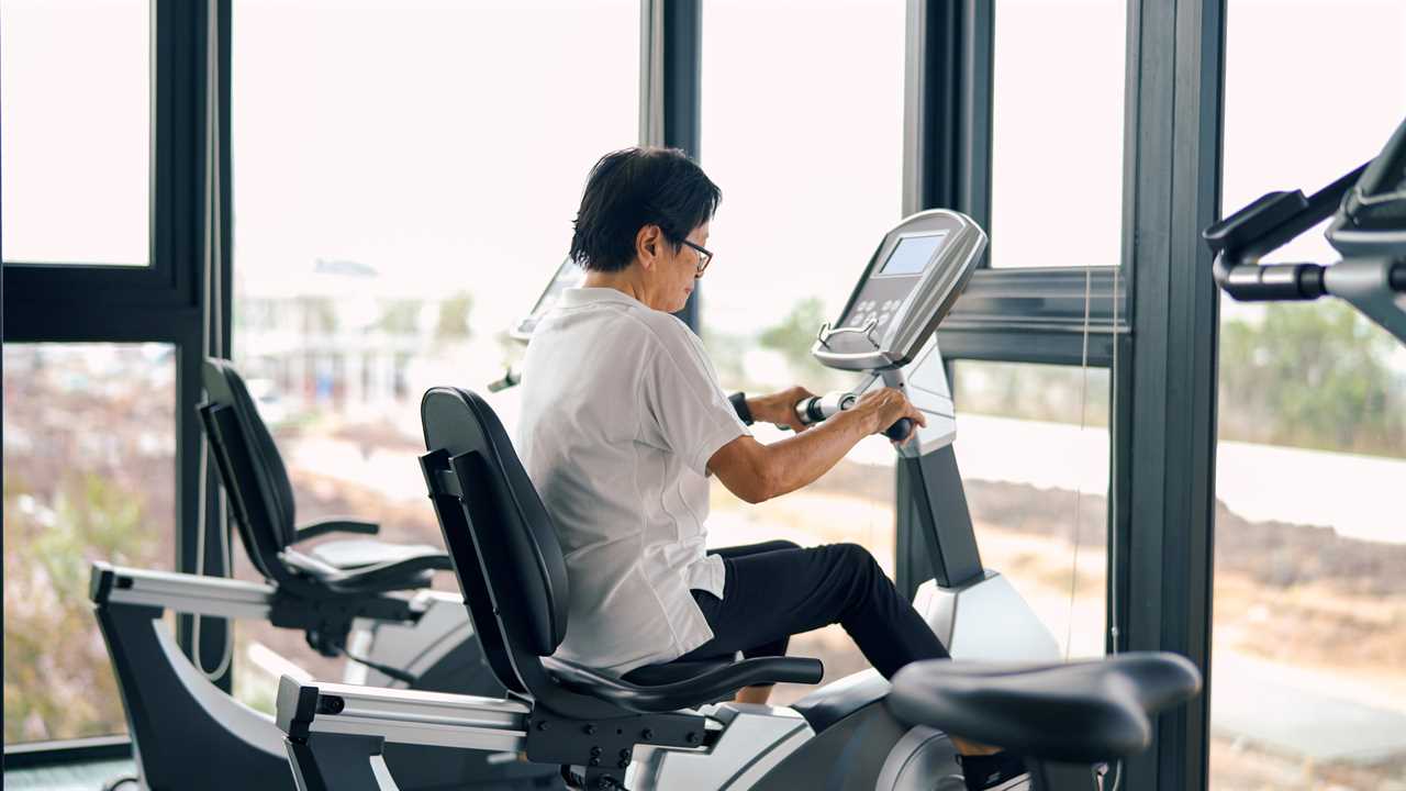 Senior woman riding on stationary at gym.