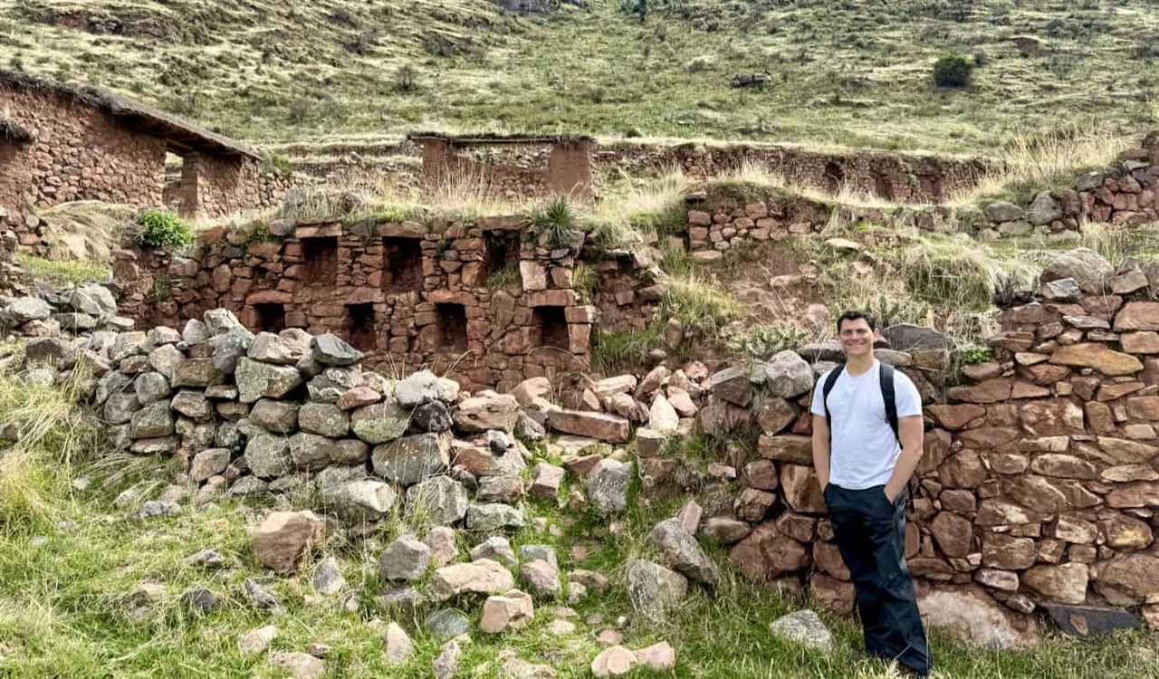 Nomadic Matt posing for a photo while hiking in the mountains of Peru on a cloudy day