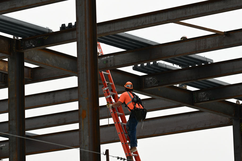 A construction worker climbs a ladder at LAX airport.