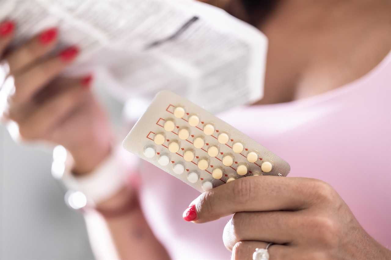 The woman holds contraceptive pills in one hand and instructions for use in the other