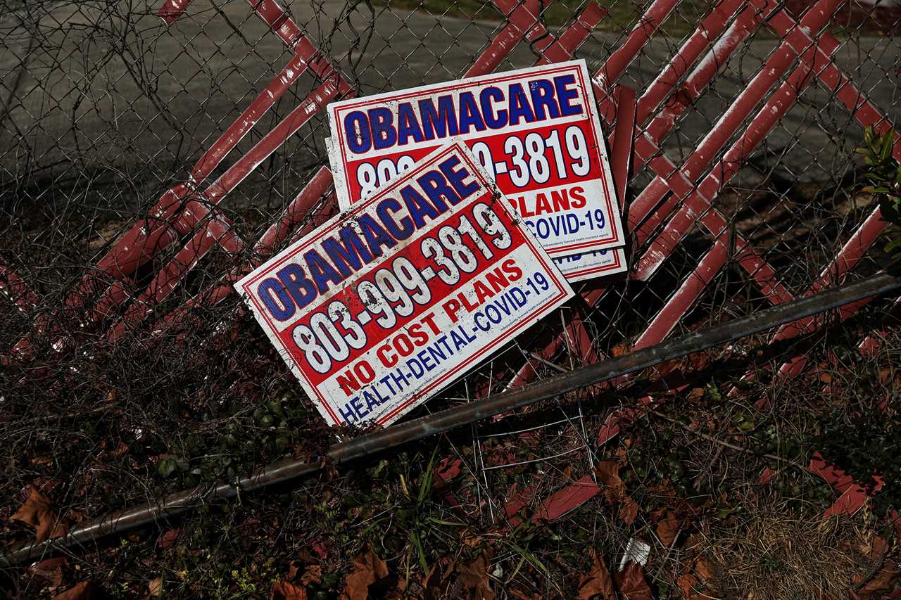 Signs for former Obamacare health insurance plans lay next to a fence in Columbia, South Carolina