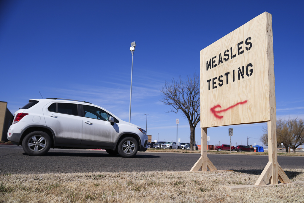 A vehicle drives past a sign outside of Seminole Hospital District offering measles testing in Seminole, Texas, on Feb. 21, 2025.
