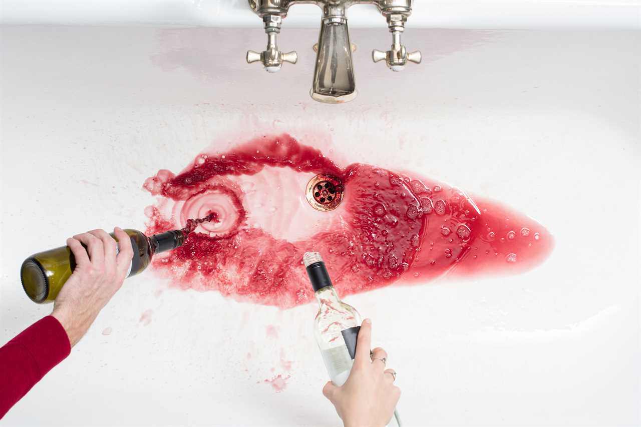 Pouring away wine in an act of giving up alcohol