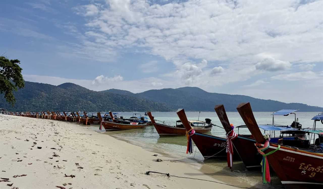 lots of longtail boats lining the beaches near the island of Ko Lipe in Thailand