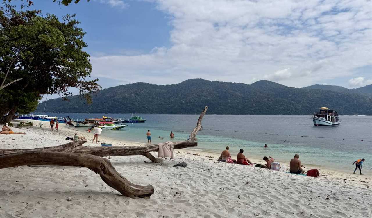 Tourist and boats on Ko Rawi in Thailand on a beach